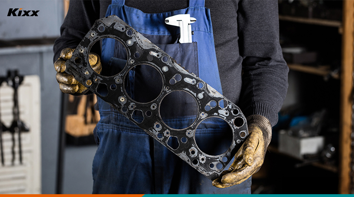 An engineer holding a cracked gasket being repaired at a service center to prevent oil leaks