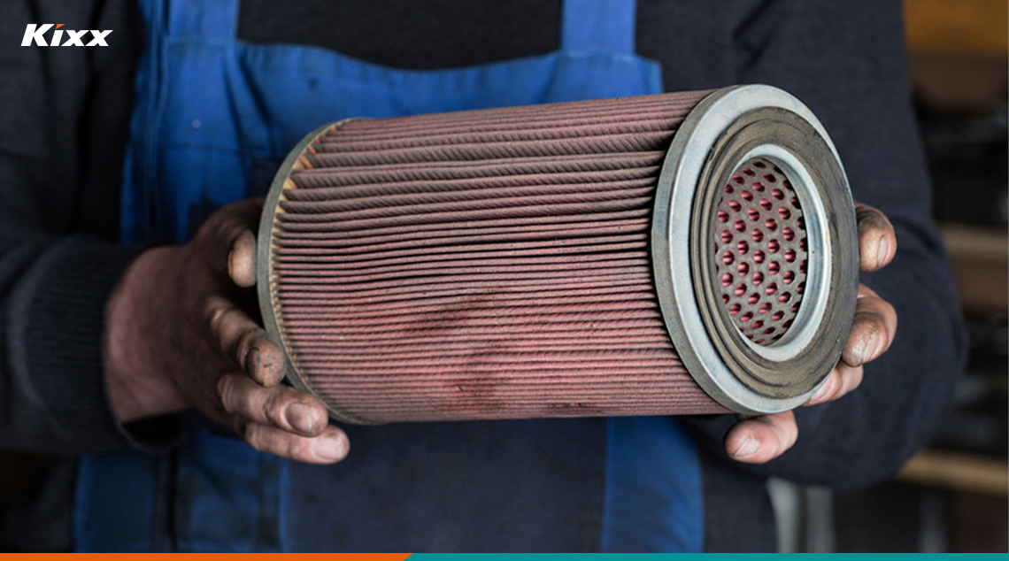 An engineer holding an oil filter to check if it had been installed too loosely