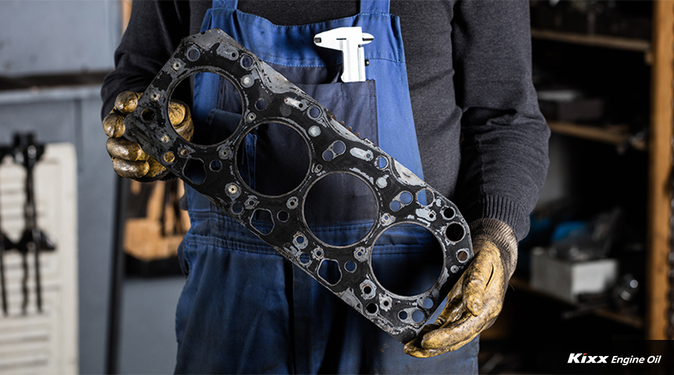 An engineer holding a cracked gasket being repaired at a service center to prevent oil leaks