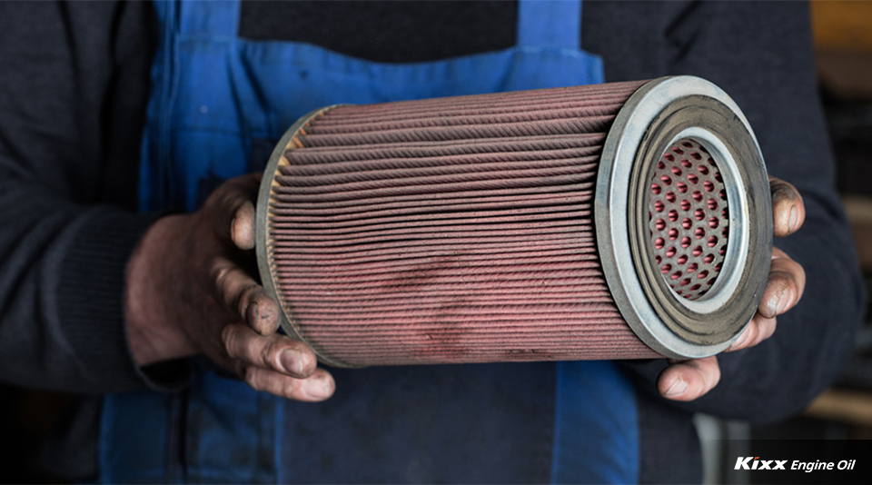 An engineer holding an oil filter to check if it had been installed too loosely
