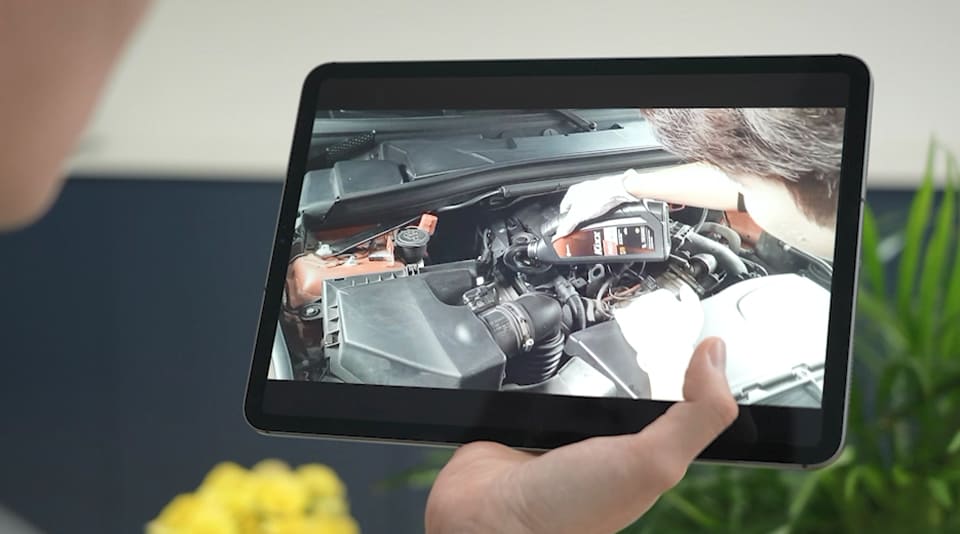 A customer remotely observes his oil change taking place via live video stream on a tablet