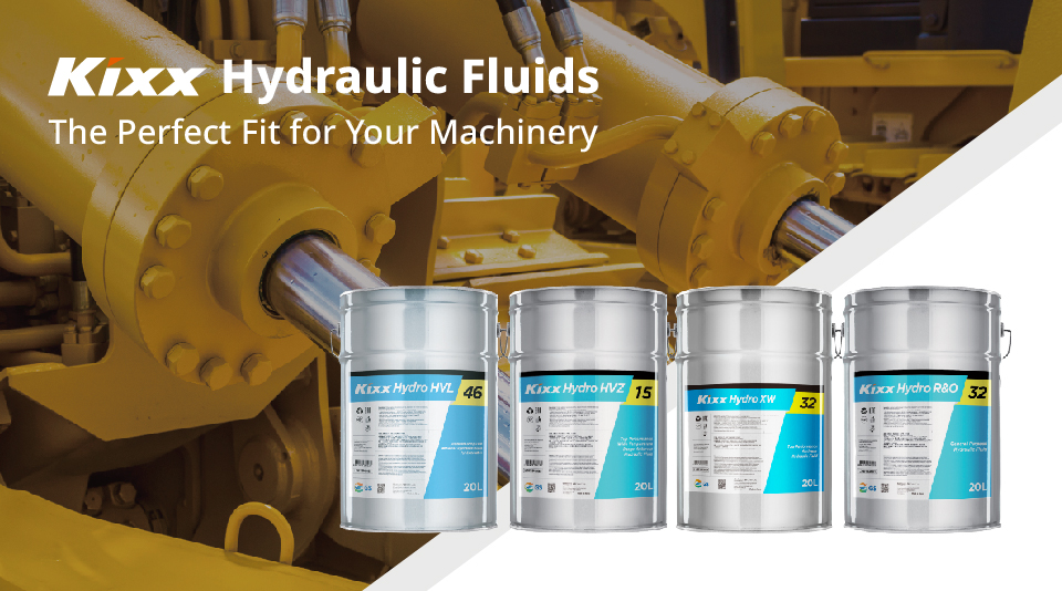 A shining yellow and chrome hydraulic system with three varieties of Kixx Hydraulic Fluid in the foreground in grey and blue drums.
