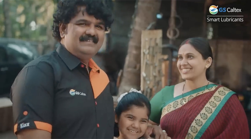 A still shot from the #GaardiKeDoctor video shows character Ganesh standing with his wife and daughter