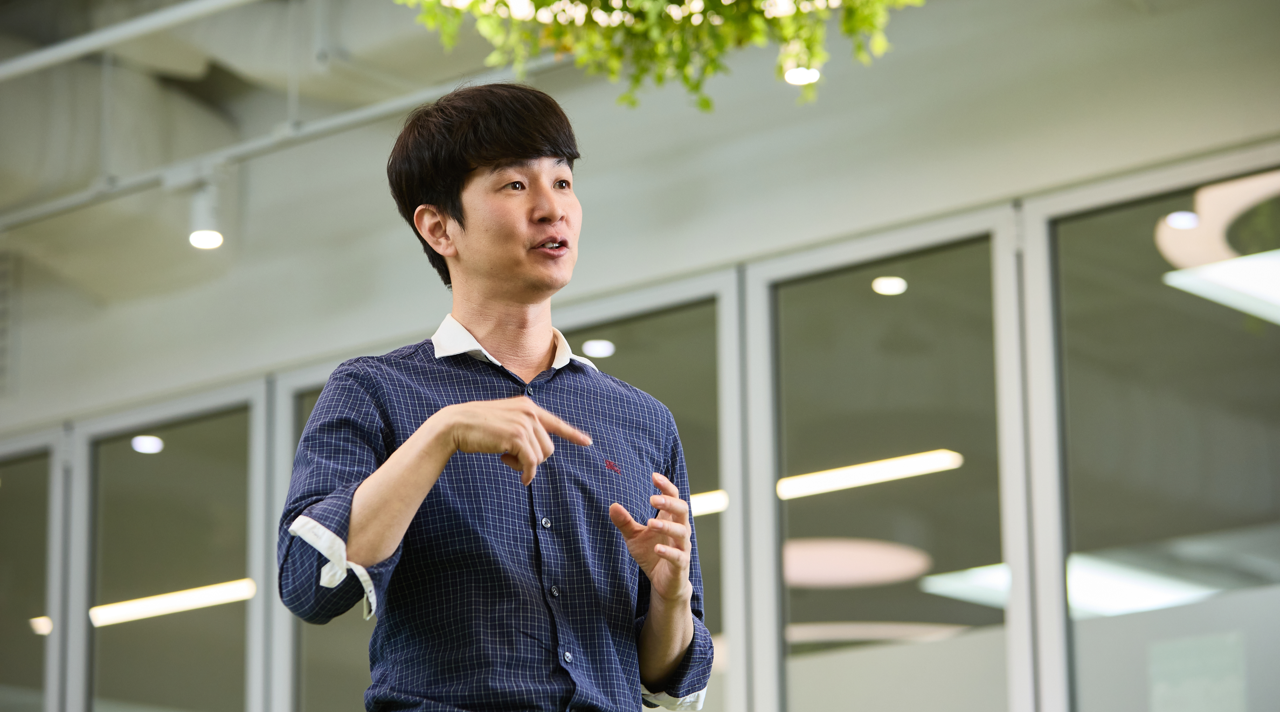 사무실에서 손짓을 섞어가며 이야기하는 최관희 책임