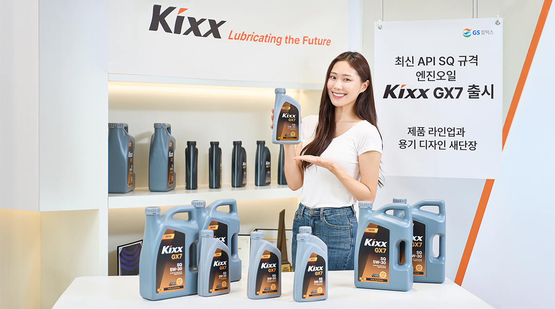 모델이 Kixx GX7 엔진오일 제품을 소개하고 있는 이미지로, 모델 앞에는 다양한 용량의 제품들이 진열되어있으며 배경에는 브랜드 리뉴얼 및 신제품 출시 소식을 홍보하는 배너가 있음