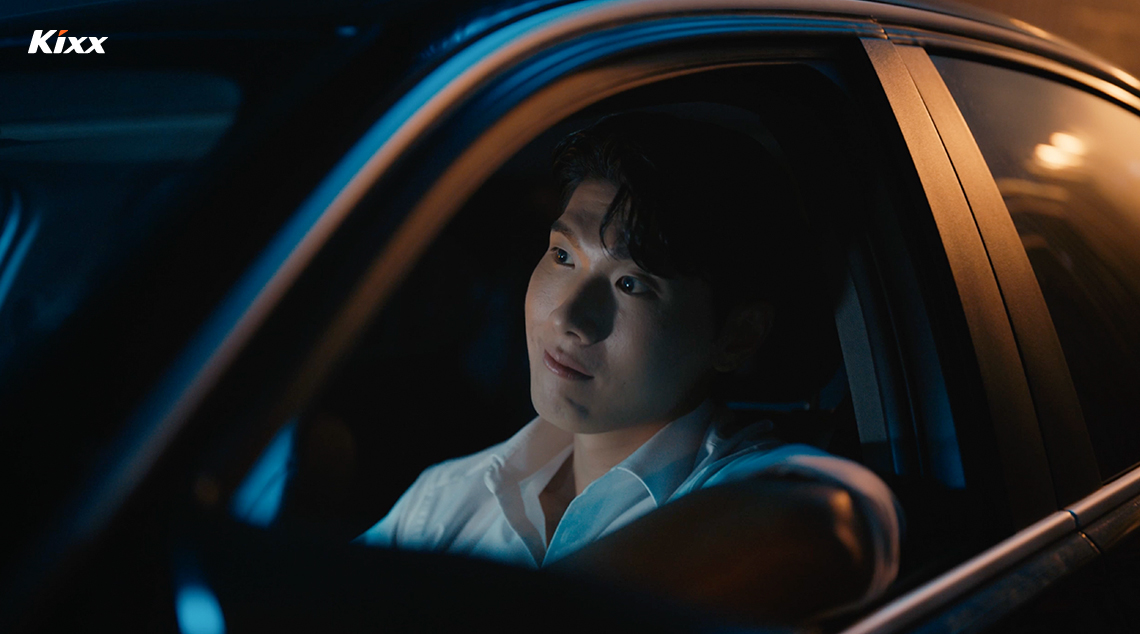Close-up of a young man sitting inside a car, looking through the windshield.