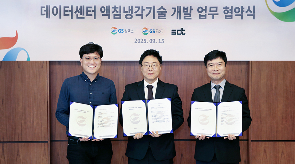 Three men holding an agreement at a data center immersion cooling technology signing ceremony.