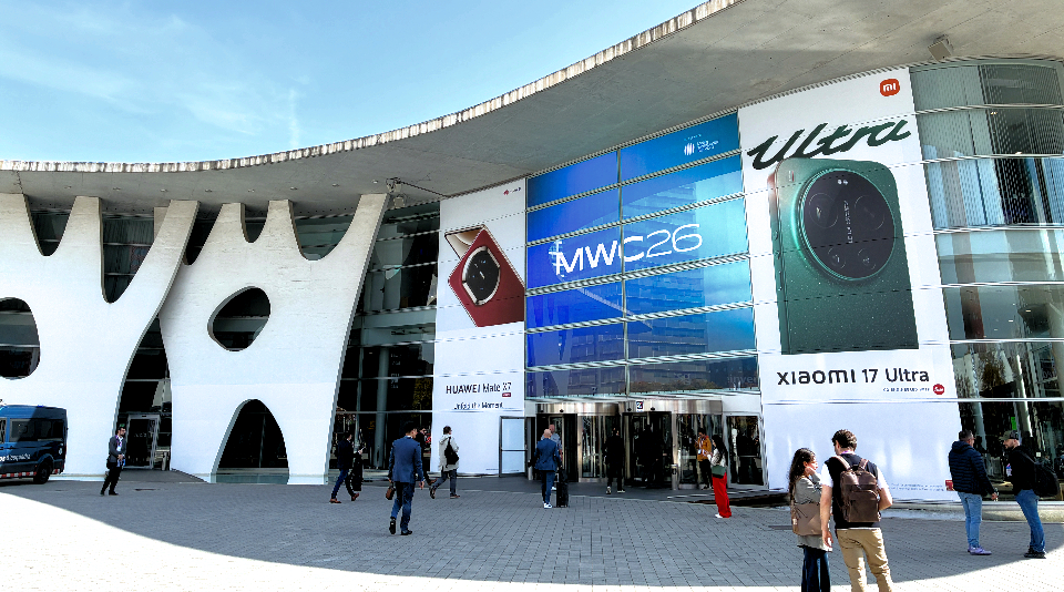 전시장 외벽에 ‘MWC26’ 배너가 걸려 있고, 참가자들이 입구로 이동하는 모습
